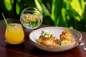 a bowl of food and a glass of orange juice at Anansaya La Maison in Siem Reap