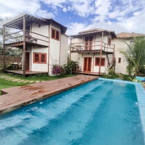 a villa with a swimming pool in front of a house at Pousada Vila Cacau in Serra Grande