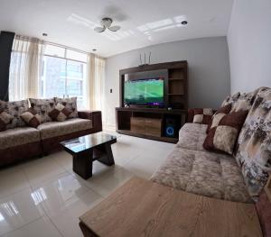 sala de estar con sofá y TV de pantalla plana en Departamento amplio y bonito en Arequipa, en Arequipa