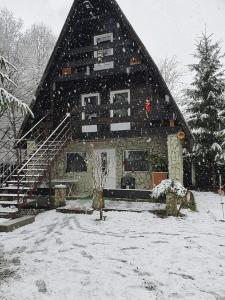 Una casa grande con nieve en el costado. en Cabanuta Dan & Alex, en Cârţişoara