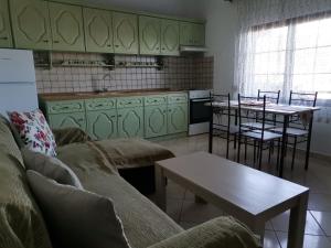 a living room with a couch and a table and a kitchen at Ioanna's Apartment in Potamia