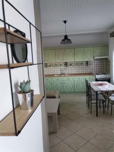 a kitchen with green cabinets and a table with chairs at Ioanna's Apartment in Potamia
