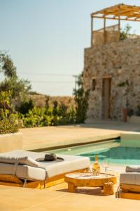 a swimming pool with chairs and a table and a swimming pool at Meli Suites Isle - Adults Only in Skala Potamias