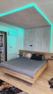 Cette chambre dispose d'un grand lit et d'un plafond bleu. dans l'établissement Apartman Pannonica, à Tuzla