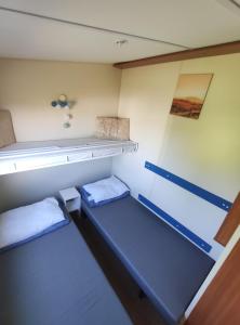 a small room with two beds on a boat at Domki GAMA in Gąski