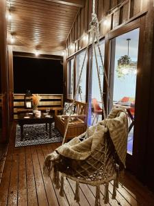 um quarto com rede de descanso e uma sala de estar com televisão em Wooden Cosy Retreat Hunters Quay em Dunoon