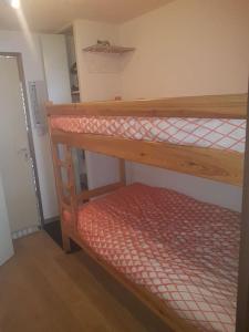 a bunk bed in a room with a red mattress at Saint lary soulan village T2 Avec parking in Saint-Lary-Soulan