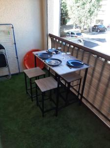 a table with chairs and plates on it on a balcony at Saint lary soulan village T2 Avec parking in Saint-Lary-Soulan