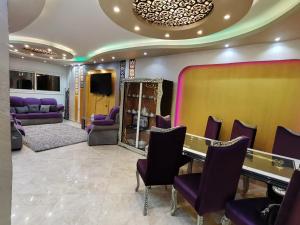a dressing room with purple chairs and a table at Alnahas St. Two-Bedroom Apartment With Jacuzzi in Tanta