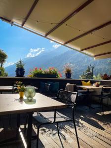 ein Restaurant mit Tischen und Stühlen und Blick auf die Berge in der Unterkunft TENNE Arlberg - Boutique Hotel & Restaurant in Sankt Anton am Arlberg