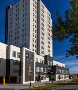 Halifax Tower Hotel & Conference Centre, Ascend Hotel Collection في هاليفاكس: مبنى أبيض طويل أمام مبنى