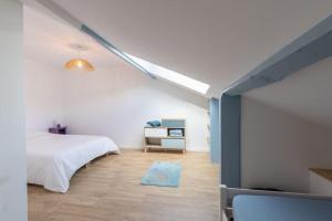 1 dormitorio con cama blanca y pared azul en Cabana & L' Horeb - Hypercentre, en Paray-le-Monial