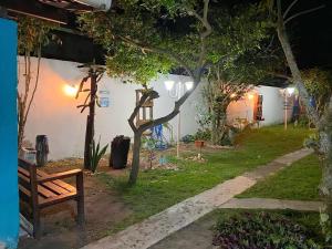 eine Parkbank in einem Garten in der Nacht in der Unterkunft Pousada Canto de Paz in Porto Seguro
