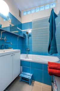 a blue bathroom with a tub and a sink at Retro Art room in Lomnice nad Popelkou