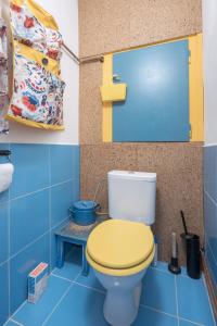 uma casa de banho com um WC amarelo e um piso azul em Retro Art room em Lomnice nad Popelkou