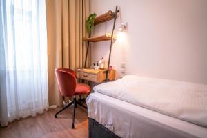 1 dormitorio con cama, escritorio y silla en Boutique Hotel Kerlin, en Berlín