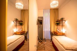 a hotel room with two beds and a mirror at Boutique Hotel Kerlin in Berlin