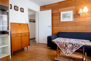 ein Wohnzimmer mit einem blauen Sofa und einem Tisch in der Unterkunft Hummerklippen Ferienwohnungen in Helgoland