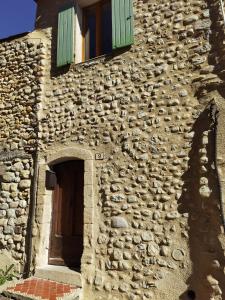 een stenen gebouw met een deur en een raam bij Maison avec vue sur la vallée d'Asse in Saint-Julien-dʼAsse