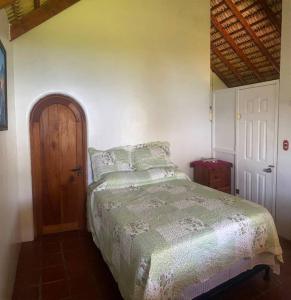 1 dormitorio con 1 cama y puerta de madera en Lake Front house, cozy and comfortable. en Santa Cruz La Laguna