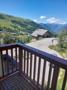 a wooden balcony with a view of a road at Appartement cosy 27 m2 idéal 5 personnes in Saint-François-Longchamp