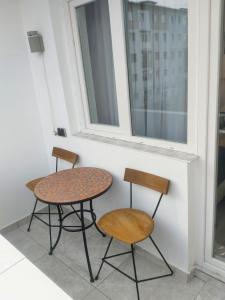 due sedie e un tavolo accanto a una finestra di Breaza Comfort Apartment a Breaza
