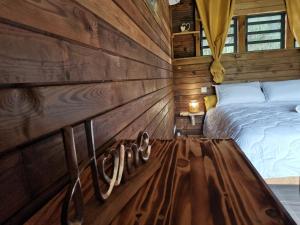 una camera con un letto su una parete in legno di Odyssea Caraïbes Cottages & Spa a Saint-Louis