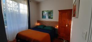 een kleine slaapkamer met een bed en een raam bij Chambre d'hôte le jardin de l'Esplanade Rennes Centre et gare in Rennes