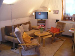 uma sala de estar com um sofá e uma mesa em Haus mit Lilie und Rose em Westerdeichstrich
