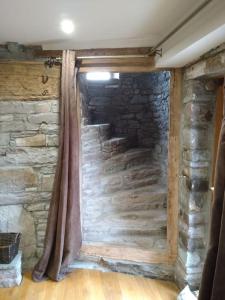 eine Steinmauer in einem Zimmer mit einem Vorhang in der Unterkunft Wern Ddu, Defynnog - Brecon Beacons in Brecon