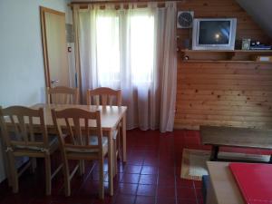comedor con mesa, sillas y TV en Apartment Lake Bohinj no. 5, en Bohinj