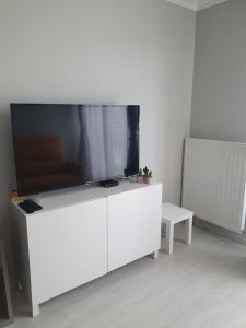 białe centrum rozrywki z dużym telewizorem z płaskim ekranem w obiekcie studio tout confort près de Disney w mieście Serris
