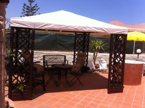 a gazebo with a table and chairs under it at Beb Eclissi in Fontane Bianche