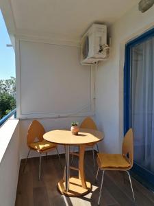 バオシチにあるApartmani Pasaraの窓付きの客室で、小さなテーブルと椅子が備わります。