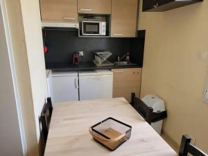 una pequeña cocina con mesa y microondas en Teïva, en Longeville-sur-Mer