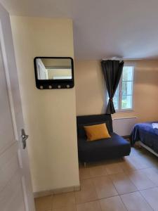 a room with a mirror and a couch and a bed at Teïva in Longeville-sur-Mer