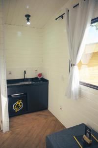 a kitchen with a sink and a window at Cabanas All Black in Monte Verde +72 photos