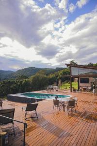 a patio with a table and chairs and a pool at All Black Resort in Monte Verde