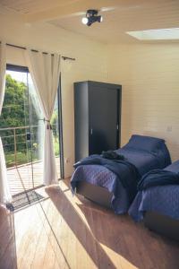 a bedroom with a bed and a large window at All Black Resort in Monte Verde