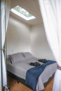 um quarto com uma cama com dois sapatos em All Black Resort em Monte Verde
