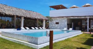 a swimming pool with lounge chairs next to a building at Mikiki Lifestyle Hotel in Barra Grande