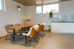 a dining room with a wooden table and chairs at VOO residence in Malečnik