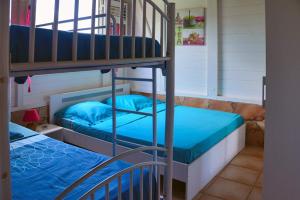 a bedroom with two bunk beds with blue sheets at Villa créole et bien etre exclusif avec piscine et jacuzzi privé in Le Diamant +40 photos
