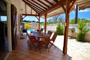 un patio con mesa y sillas en Villa Sohalia climatisée, piscine et jardin à 5mn de la plage en Le Diamant