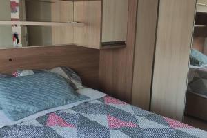 um quarto com uma cama e uma cabeceira em madeira em Apartamento Lindo e Confortável com 2 quartos e estacionamento grátis Curitiba em Curitiba