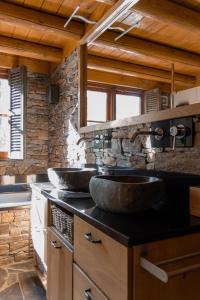 a kitchen with two sinks and a stone wall at Lutterlodge in De Lutte