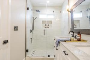 a white bathroom with a shower and a sink at New 5 bed w/hot tub close to Universal sleeps 12 in Los Angeles +37 photos
