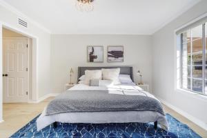 a white bedroom with a large bed with a blue rug at New 5 bed w/hot tub close to Universal sleeps 12 in Los Angeles