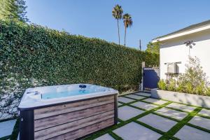 a jacuzzi tub in a backyard with a hedge at New 5 bed w/hot tub close to Universal sleeps 12 in Los Angeles