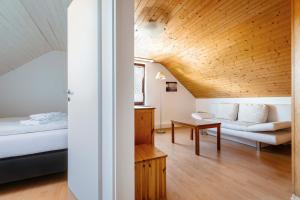ein Schlafzimmer mit einem Bett, einem Sofa und einem Tisch in der Unterkunft Hummerklippen Ferienwohnungen in Helgoland